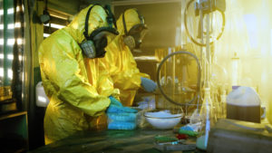 Two technicians in yellow hazmat suits in laboratory